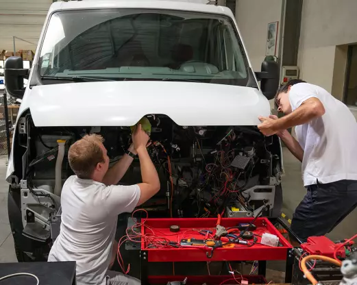 Techniciens TOLV en train de rétrofiter un véhicule utilitaire dans l'atelier TOLV